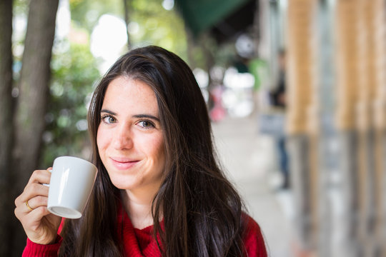 Portrait of happy beautiful brunette with mug in hand