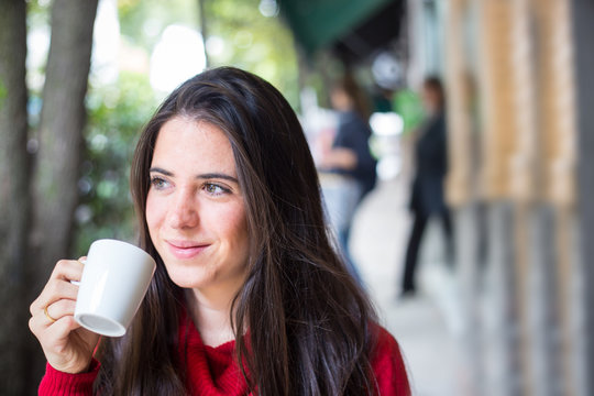 Portrait of happy beautiful brunette with mug in hand
