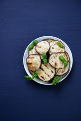Above view of grilled aubergine with green basil leaves