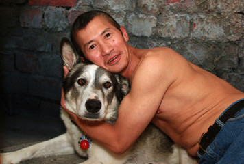 Asian Man Hugging his Malamute Dog