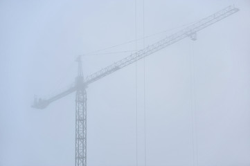 Construction crane in dense fog