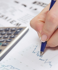 A close-up image of a hand with a pen  showing a diagram