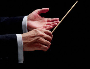 Hands of a conductor on black background