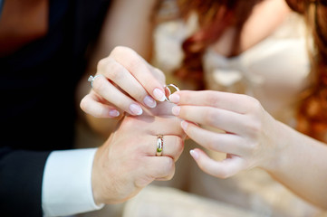 Bride and groom holding their wedding rings