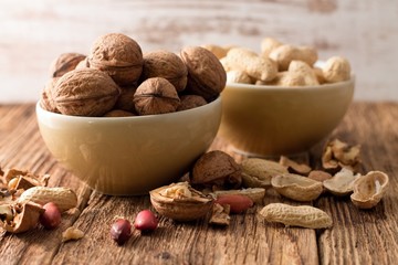 Bowl with walnuts in front and with peanuts back
