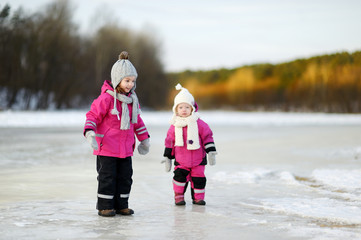 Two little sisters having fun on snowy winter day