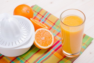 orange juice beside delicious ripe oranges on the table