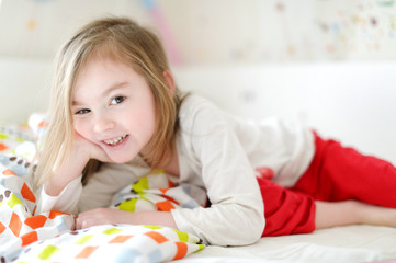 Obraz na płótnie Canvas Little girl in bed on sunny morning