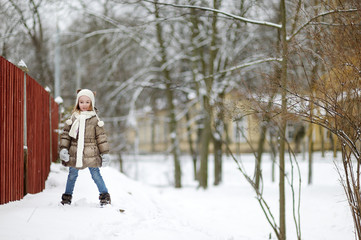 Fototapeta na wymiar Adorable little girl having fun on winter day
