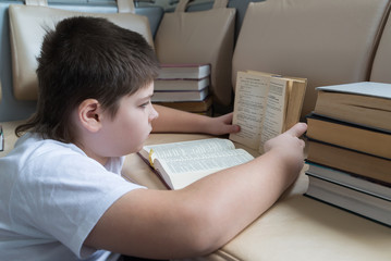 Teenager boy reading a book in room