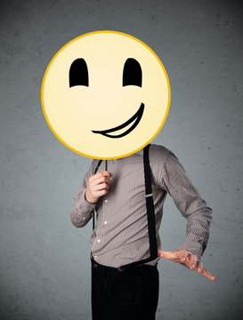 Businessman holding a smiley face emoticon