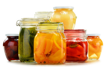 Fototapeta na wymiar Jars with pickled vegetables and fruity compotes on white