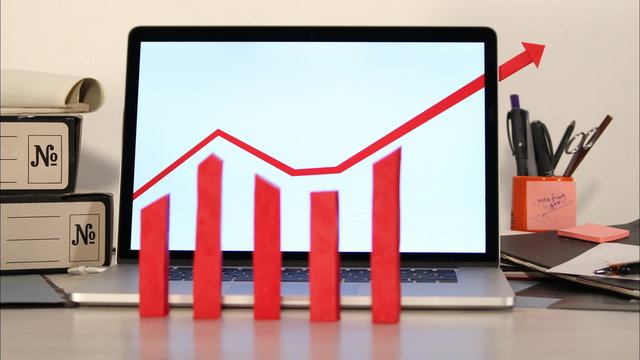 Growing graph with arrow out of laptop screen