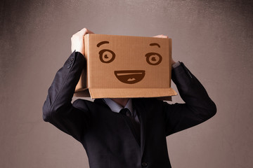 Businessman gesturing with a cardboard box on his head with smil