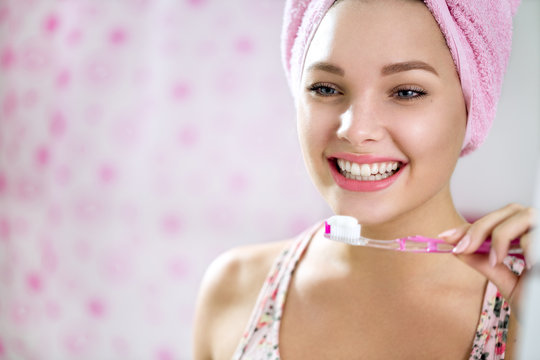 Smiling young girl brushing teeth