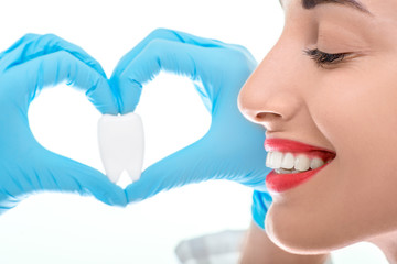 Portrait of dentist with tooth on white background