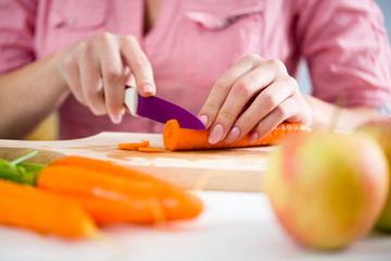 Hands of a young woman chopping vegetables