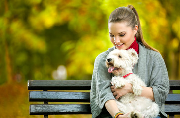 Young woman holding cute maltese dog