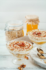 Tasty dessert with oat flakes and honey, on table