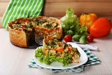 Piece of Vegetable pie with broccoli, peas, tomatoes and cheese