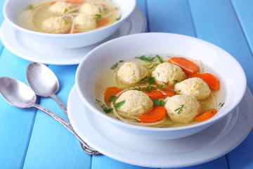 Soup with meatballs and noodles in bowls