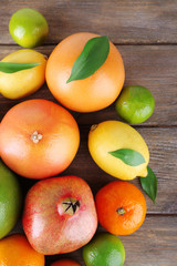 Ripe citrus with green leaves on wooden background