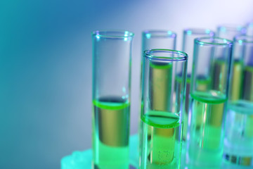 Green fluid in test-tubes on the light background