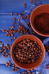 Two bowls of ground coffee and coffee beans