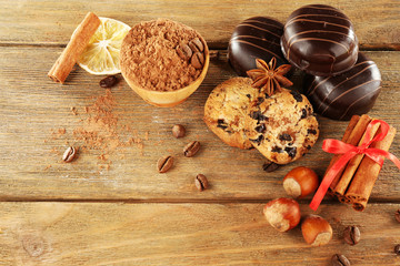 Chocolate cookies with bowl of cocoa, nuts, coffee beans, slice