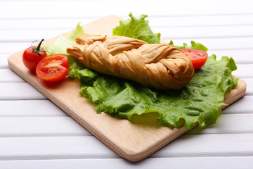Smoked braided cheese on wooden table