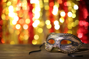 Beautiful carnival mask on table on bright background