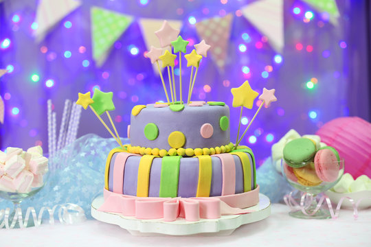 Delicious birthday cake on shiny purple background