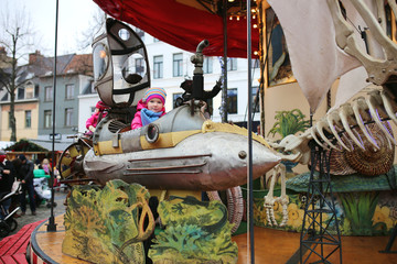 Cheerful toddler girl enjoying merry-go-round