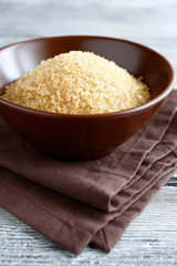 Brown sugar in the bowl on a wooden board