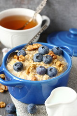 Oatmeal with fresh blueberries over a rustic wooden background