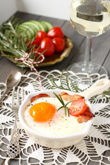 Breakfast on wooden tray, fried egg with bacon and vegetables