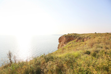 High green cliffs and precipices above the sea in a gentle sunse