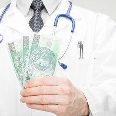 Doctor holding money in his hand - health care concept