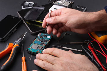 Tecnico al lavoro nel riparare cellulari guasti