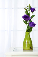 Beautiful bouquet of flowers in vase on window background