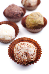 Sweet round candy wrapped in paper bowl on white background