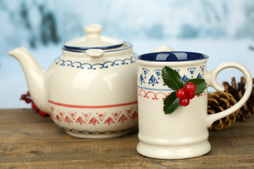 Christmas composition with cup and teapot of hot drink,
