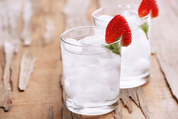 Glasses with ice cubes on wooden table