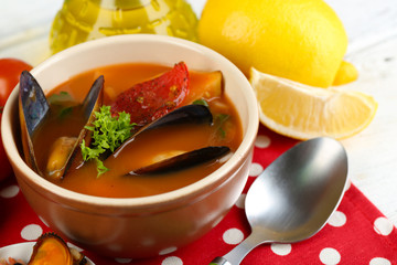 Tasty soup with shrimps, mussels, tomatoes and black olives in