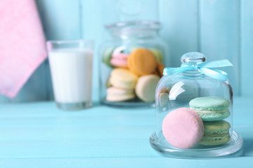 Gentle colorful macaroons in glass jell jar, milk glass and