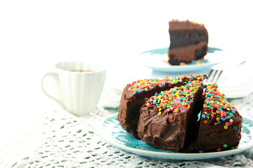 Chocolate cake with colorful sweet powder on table close-up