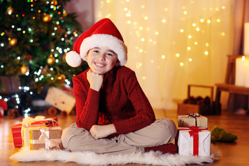 Little boy sitting near fireplace in room