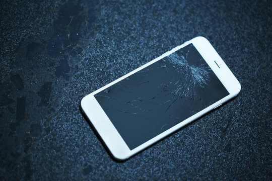 Broken IPhone On Asphalt Outdoors