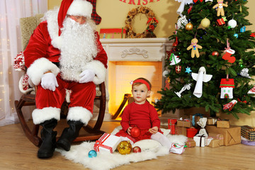 Santa Claus giving  present to  little cute girl near