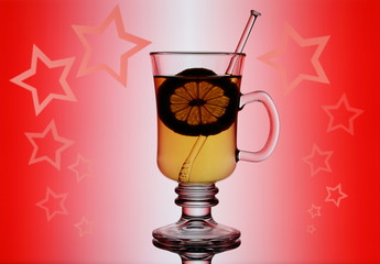 Yellow mulled wine on red background with lemon